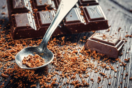 Close up of dark chocolate and spoon on dark wooden backgroundの写真素材