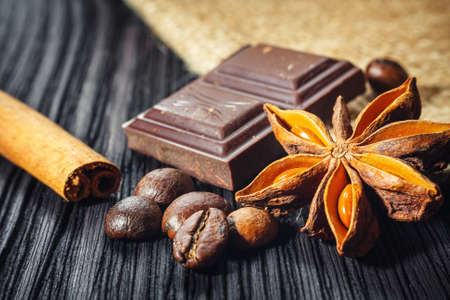 Chocolate bar and spices on wooden table, close upの写真素材