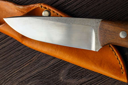 Hunting knifelying on wooden board, top viewの写真素材