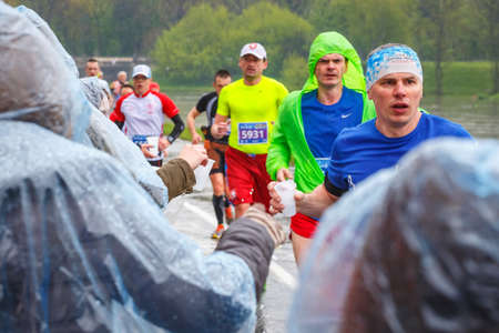 KRAKOW, POLAND - April 30, 2017: Unidentified Marathon runner picking up water at service point...