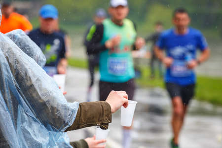 KRAKOW, POLAND - April 30, 2017: Unidentified Marathon runner picking up water at service point...