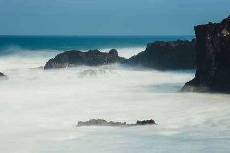 Los Hervideros, volcanic coastline with wavy ocean and blue sky, Long time exposure