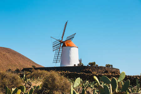 Windmill on blue sky background in cactus garden, Guatiza village, Lanzarote, Canary islandsの写真素材