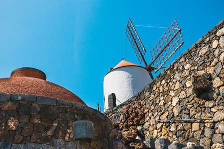 Windmill on blue sky background in cactus garden, Guatiza village, Lanzarote, Canary islandsの写真素材
