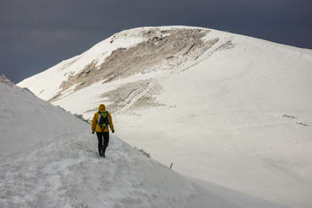 Mountain hiker in bad weather during winterの写真素材