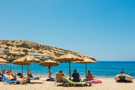 Crete Island, Greece, June 09, 2017: Panorama of Matala beach. Caves on the rocks were used as a roman cemetery and at the decade of 70's were living hippies from all over the world, Crete, Greeceの写真素材