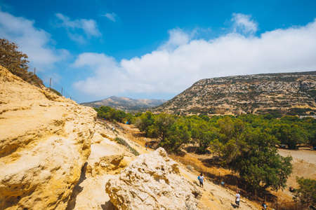 Crete Island, Greece, June 09, 2017: Panorama of Matala beach. Caves on the rocks were used as a roman cemetery and at the decade of 70's were living hippies from all over the world, Crete, Greeceのeditorial素材
