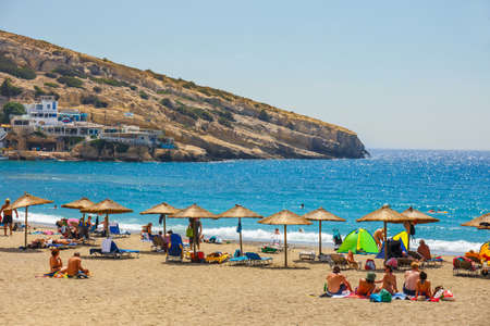Crete Island, Greece, June 09, 2017: Panorama of Matala beach. Caves on the rocks were used as a roman cemetery and at the decade of 70's were living hippies from all over the world, Crete, Greeceのeditorial素材