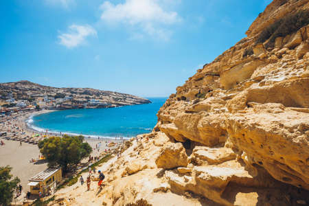 Crete Island, Greece, June 09, 2017: Panorama of Matala beach. Caves on the rocks were used as a roman cemetery and at the decade of 70's were living hippies from all over the world, Crete, Greeceのeditorial素材