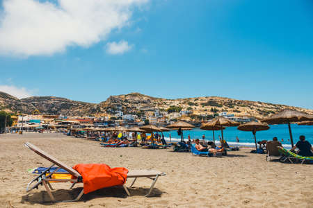 Crete Island, Greece, June 09, 2017: Panorama of Matala beach. Caves on the rocks were used as a roman cemetery and at the decade of 70's were living hippies from all over the world, Crete, Greeceのeditorial素材