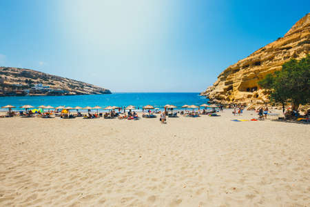 Crete Island, Greece, June 09, 2017: Panorama of Matala beach. Caves on the rocks were used as a roman cemetery and at the decade of 70's were living hippies from all over the world, Crete, Greeceのeditorial素材