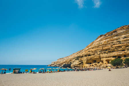 Crete Island, Greece, June 09, 2017: Panorama of Matala beach. Caves on the rocks were used as a roman cemetery and at the decade of 70's were living hippies from all over the world, Crete, Greeceのeditorial素材