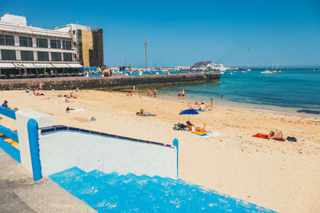 Corralejo, Furteventura, Spain - April 03, 2017: View of public beach in Corralejo with the port in the backgroundのeditorial素材