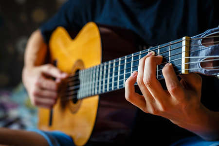 young musician playing acoustic guitar, live music backgroundの写真素材