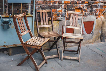 many empty wooden chairs outside the restaurantの写真素材