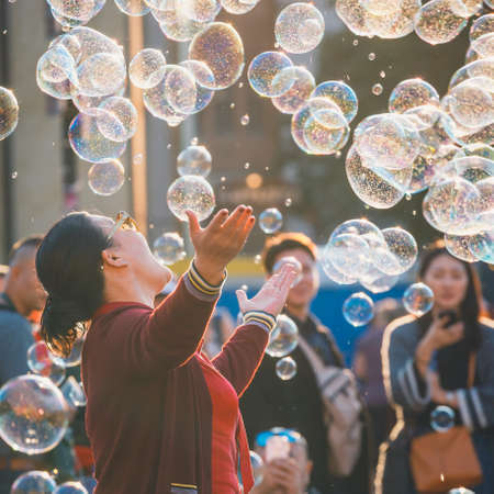 Prague, Czech Republic, September 29, 2017: Unidentified young woman catching the soap bubbles in Old Town Square in Prague, Czech Republicのeditorial素材