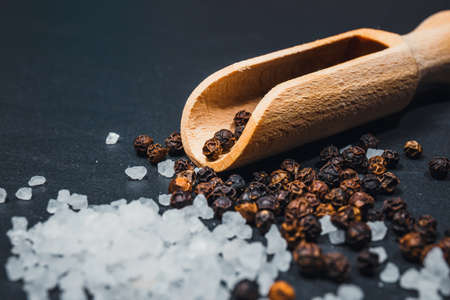 Black pepper and salt on rustic stone background.の写真素材