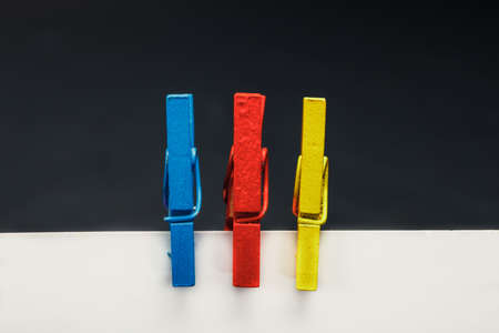 Close up of a note paper and clothes pegs on a black background