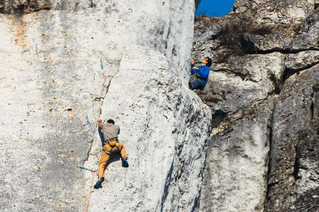 Poland, Podlesice - March 04, 2017: Side view of adult male rock climber on vertical flat wall with poor relief. Gora Zborow is a very popular destination among climbersのeditorial素材