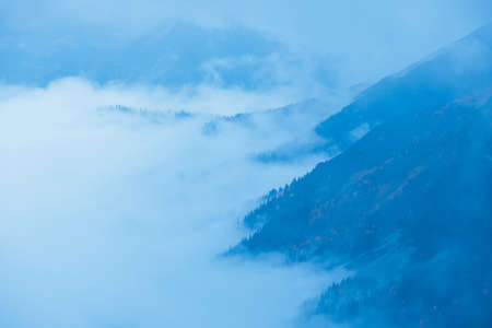foggy mountain landscape with clouds above the peaksの写真素材