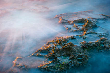 long exposure of sea and rocks at sunsetの写真素材