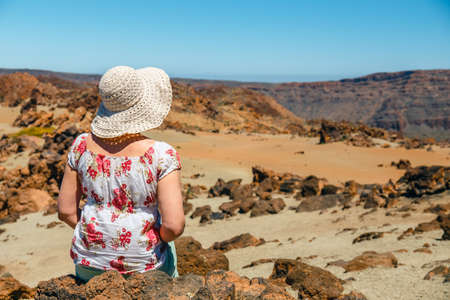 a young woman is walking in the mountains and admires beautiful viewsの写真素材