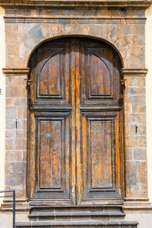 old brown wooden doors on brick wallの写真素材