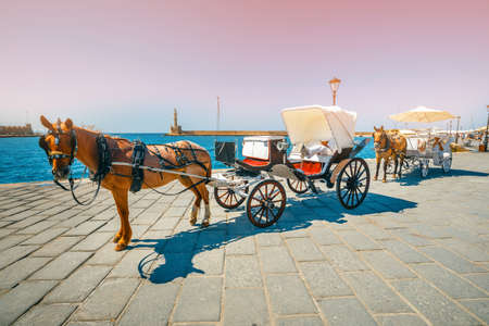 Chania, Crete - 23 Maj, 2016: Horse carriage for transporting tourists in old port of Chania on Crete, Greece. Chania is the second largest city of Crete and and a very popular city visited by touristsのeditorial素材