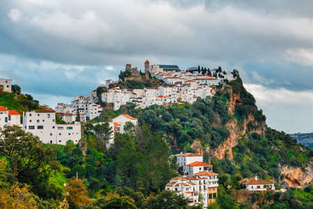 White Andalusian village - pueblo blanco - in the mountain range in Casares during sunsetの写真素材