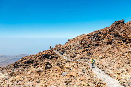 Tenerife, Spain, June 07, 2015: unknown people are walking along the mountain path at the top of the el teide volcano, Spainのeditorial素材