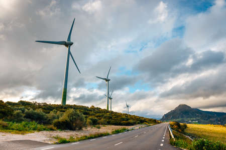 Windmills for electric power production in mountain during sunsetの写真素材