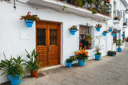 decorated facade of house with flowers in blue pots in Mijas, Spainの写真素材