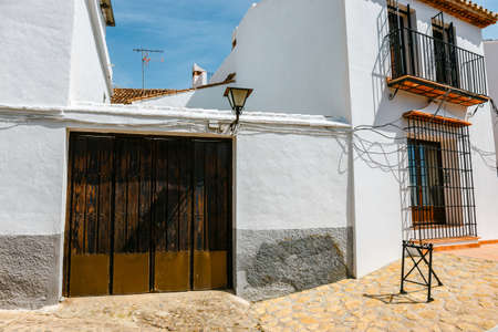 narrow street with white facades of houses in historic district of Ronda, Spainの写真素材