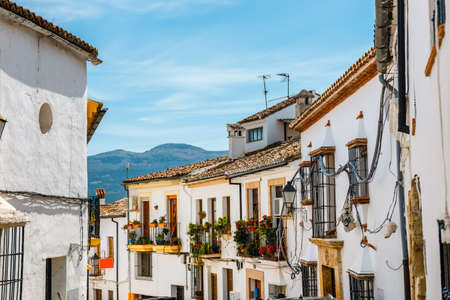 narrow street with white facades of houses in historic district of Ronda, Spainの写真素材