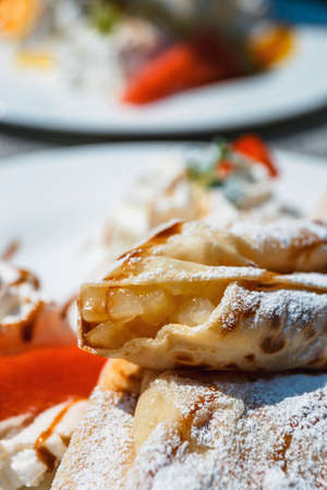 pancake with apple filling decorated with whipped cream and fresh fruitsの写真素材