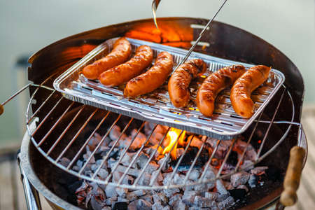 Grilled sausage on the flaming grill, close upの写真素材