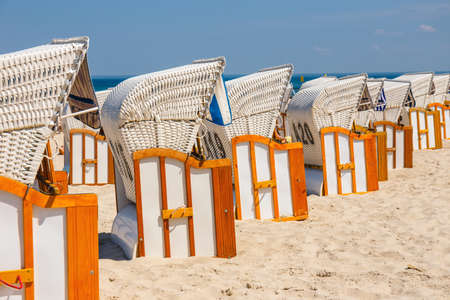 Sandy beach and traditional wicker beach baskets at sunny dayの写真素材