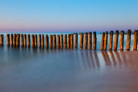 Sunset on the beach with breakwater, long time exposureの写真素材