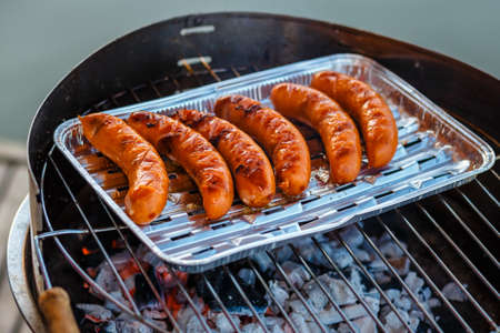 Grilled sausage on the flaming grill, close upの写真素材