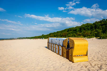 Sandy beach and traditional wicker beach baskets at sunny dayの写真素材