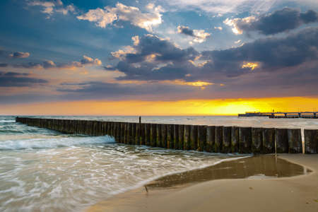 Sunset on the beach with breakwater, long time exposureの写真素材