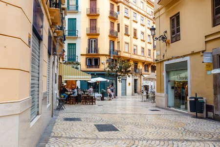 Malaga, Spain, April 03, 2018: Narrow street in the historical center of Malaga where tourists are seeking for shopsのeditorial素材