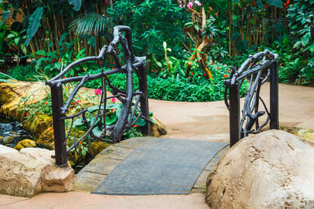 wooden arched bridge in the green gardenの写真素材
