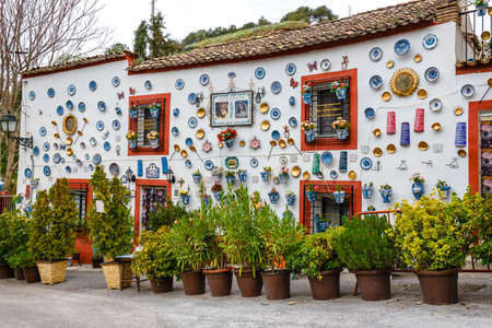 Granada, Spain, April 06, 2018: : Facade of a traditional house with decorative ceramic plates and pots of colorful flowers in the historic Albaicin neighbourhood.のeditorial素材