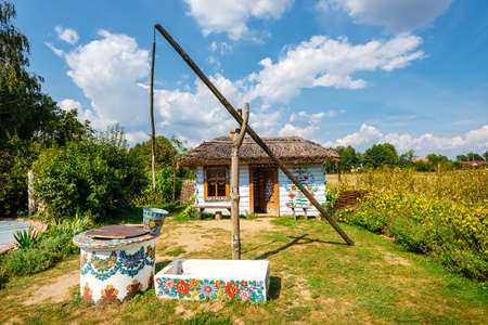 Zalipie, Poland, August 19, 2018: traditional farmstead with a well in the colorful village of Zalipie, Poland. It is known for a local custom of painting the cottages with decorative motifsのeditorial素材