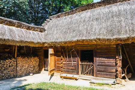 Old log house with thatched roof, traditional rural architecture in Polandの写真素材