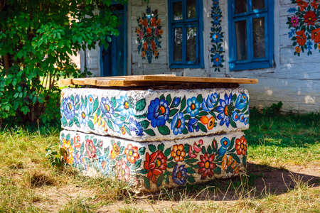 Zalipie, Poland, August 19, 2018: traditional farmstead with a well in the colorful village of...