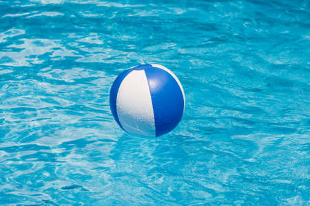 Inflatable colorful ball floating in a swimming poolの写真素材