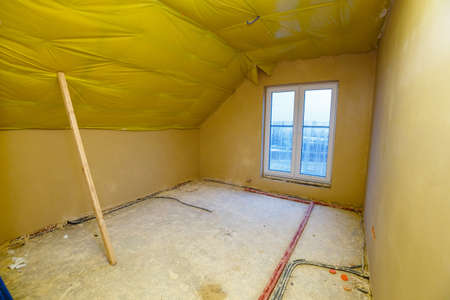 Empty room in a house under construction with fresh screed and plasterの写真素材