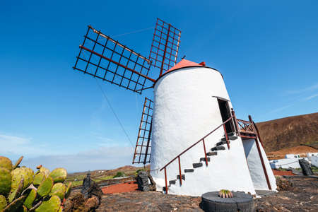 Windmill on blue sky background in cactus garden, Guatiza village, Lanzarote, Canary islandsの写真素材